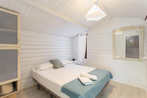 a small bedroom with a bed and a tv at Oliwood Beach - Fantasia in Playa Oliva Nova