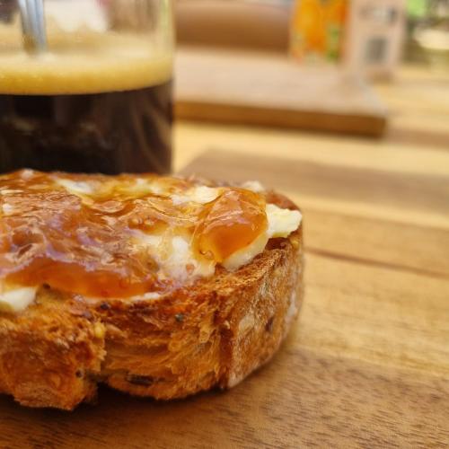 un morceau de pain posé sur une table en bois avec une boisson dans l'établissement La bulle carrée village, à Lapalme