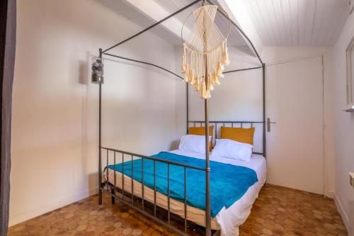 - une chambre avec un lit à baldaquin et des draps bleus dans l'établissement La Colombette - climatisée avec piscine, à Fréjus