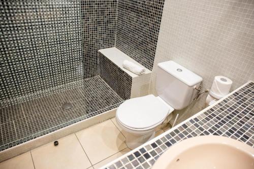 a bathroom with a toilet and a shower and a sink at Grand Hôtel Du Lido in Argelès-sur-Mer