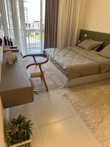 ein Schlafzimmer mit einem Bett und einem Stuhl in der Unterkunft Marassi 2-bed Marina Views Sandy Lagoon in El-Alamein