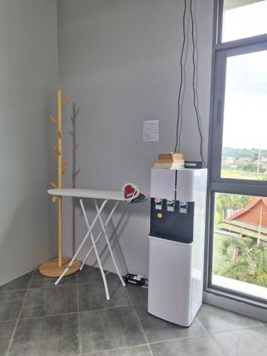 a white refrigerator and a table in a room at Atom Phuket Hotel in Nai Yang Beach