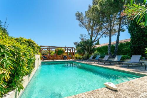 une piscine avec des chaises dans une cour dans l'établissement Charmante Villa avec piscine, à Fontvieille