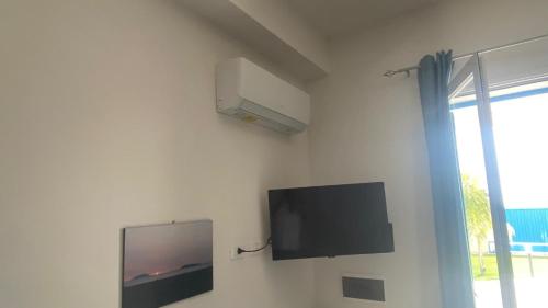 a flat screen tv on a white wall with a window at Casa Vacanze-Le stanze di Eolo in Marsala