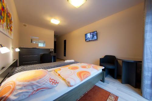 a bedroom with a bed and a tv on the wall at Pensjonat Źródełko in Ustroń