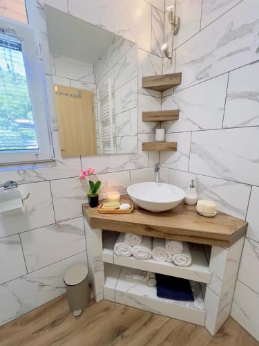 a white bathroom with a sink and a mirror at Napkelte Vendégház in Szigliget