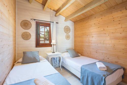 una habitación con dos camas en una cabaña de madera en Oliwood Beach - Piano, en Oliva