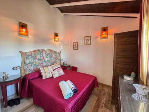 a bedroom with a pink bed with two pillows at Cortijo Los Matías in Sayalonga