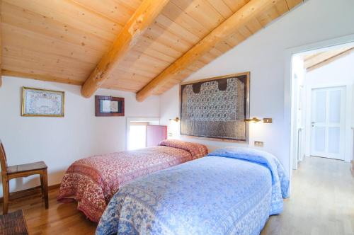two beds in a room with wooden ceilings at Chalet Monciòn in Rualp