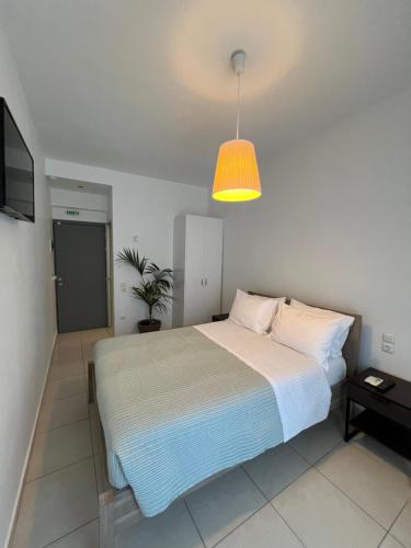 a bedroom with a bed and a potted plant at Liberte Maisonettes in Parga