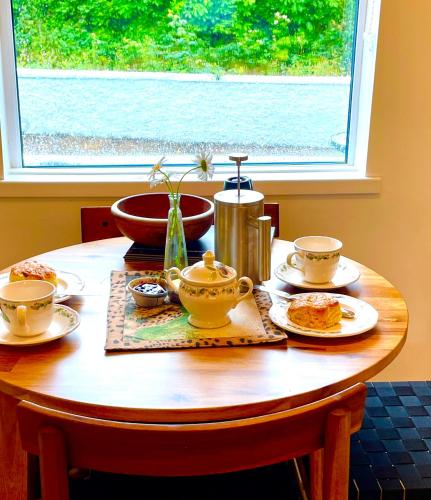 a wooden table with tea cups and plates on it at Midsummer cottage in Wexford