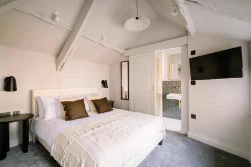 a white bedroom with a bed and a tv at Domain Boutique Rooms in Lancaster