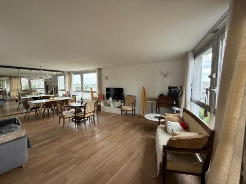 un salon avec un canapé et une table dans l'établissement Vue, espace & confort Appartement 2 chambres avec terrasse & parking, aux portes de Paris, à Puteaux
