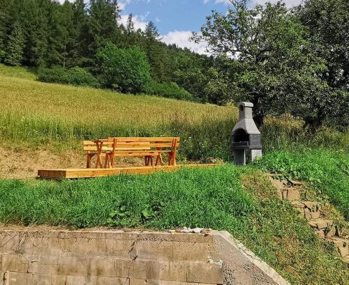 a wooden bench sitting in the middle of a field at Chata Hôrka in Kežmarok