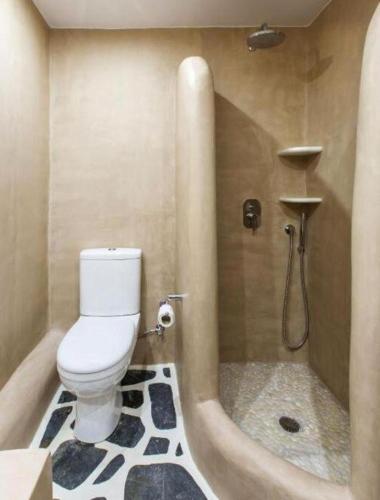 a bathroom with a toilet and a shower with a tub at Byzantio Beach Suites & Wellness in Agios Sostis