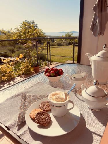a table with a cup of coffee and a plate of food at Napkelte Vendégház in Szigliget
