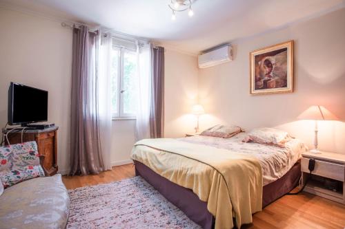 une chambre avec un lit, une télévision et une fenêtre dans l'établissement Villa de l'artiste Andrea, à Fréjus