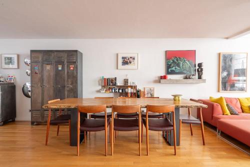 une salle à manger avec une table et un canapé dans l'établissement Veeve - Geppetto’s House, à Paris