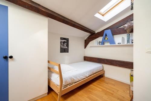 une petite chambre avec un lit dans un grenier dans l'établissement Veeve - Geppetto’s House, à Paris