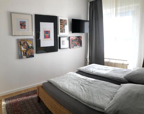 a bedroom with two beds and pictures on the wall at Tiny Atelier Leihfahrräder Gratis Shuttleservice in Bad Harzburg
