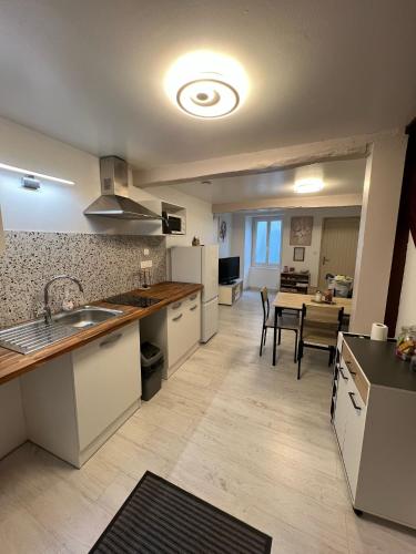- une cuisine avec un évier et une table dans une chambre dans l'établissement Charmante maison rénovée, à Nérac