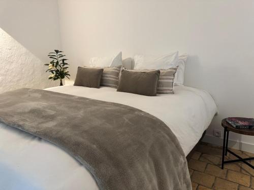 a bedroom with a large white bed with pillows at Domaine la Boulinière - Le Faisan in Journet