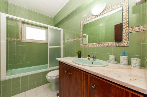 a bathroom with a sink and a toilet and a mirror at Water Tower Townhouse with Pool in Lagos