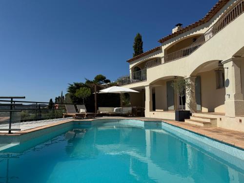 une piscine devant une maison dans l'établissement La Villa Belvédère, au Lavandou