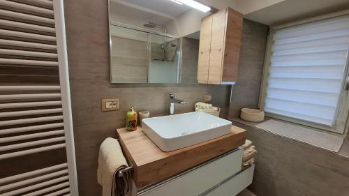 a bathroom with a white sink and a mirror at Dimora Alpina in Vermiglio