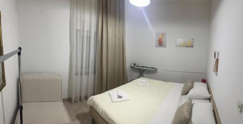 a white bedroom with a bed and a light at Apartman Antony in Čitluk