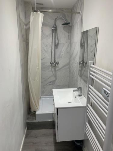 une salle de bain avec douche et lavabo dans l'établissement Le Petit Cap Normand - Calme et Reposant, à Grandcamp-Maisy