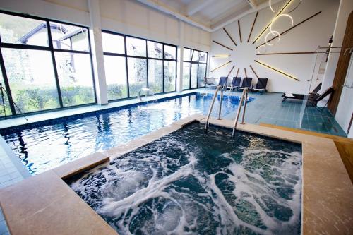 a large swimming pool with a large clock on the wall at Turističko naselje Natura Art-Hotel Opal Art in Lohovo