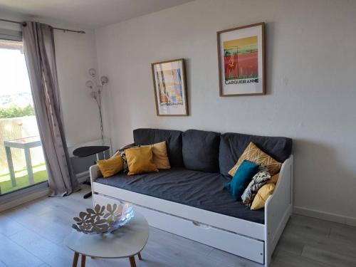 salon z kanapą i stołem w obiekcie Superbe appartement avec balcon vue mer ! w mieście Carqueiranne