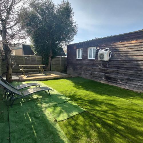 une cour avec un banc et un panier de basket dans l'établissement Chalet au cœur de la foret de Rambouillet, à Les Bréviaires
