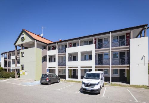 a white van parked in a parking lot in front of a building at B&B HOTEL Avignon 1 in Le Pontet
