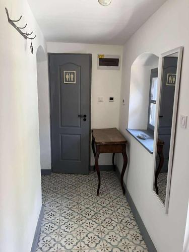 a hallway with a door and a table and a mirror at Káli-lak Vendégház in Köveskál