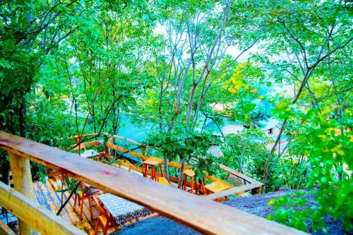une terrasse en bois avec des bancs, des arbres et de l'eau dans l'établissement Aika Sunrise - Your Home in the Hills, à Iringa