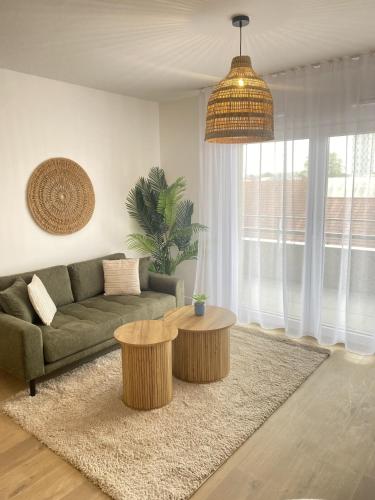 a living room with a green couch and two tables at Montana Dijon in Dijon