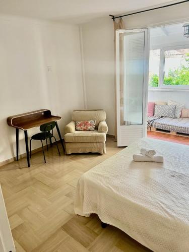 une chambre avec un lit, une table et une chaise dans l'établissement La Maison By Simone T4, à Cannes