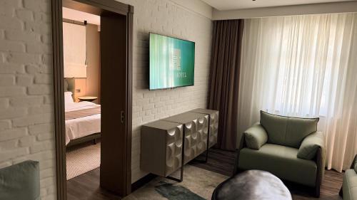 a room with a bed and a chair and a mirror at HL 309 Hotel in Tashkent