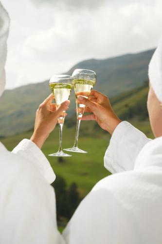 a person holding up two glasses of champagne at Hotel Macun, Vent im Ötztal in Vent