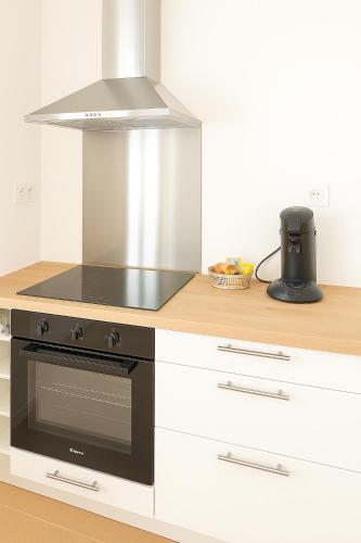 Il comprend une cuisine équipée d'un four avec plaques de cuisson noires. dans l'établissement Appartement de charme Digoin #8, à Digoin