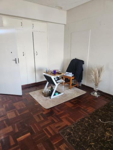 a room with a table and a chair on a wooden floor at Beautiful View House in Vosburg