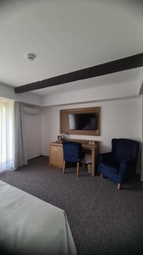 a hotel room with a bed and two chairs and a desk at New Wolf in Bran