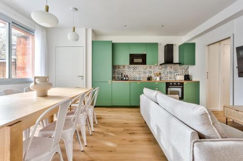 uma sala de jantar com armários verdes e uma mesa e cadeiras em Nocnoc - Le Balcon de l'Oli 99m2 em Bordéus