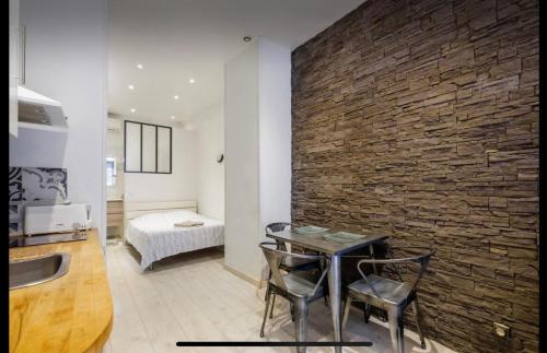 une cuisine avec une table et un mur en briques dans l'établissement studio centre port de nice, à Nice