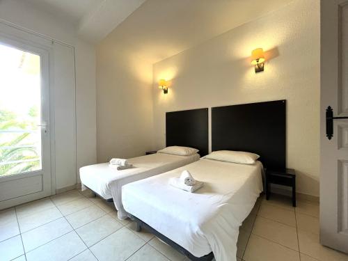 deux lits dans une chambre avec une fenêtre dans l'établissement SAINT FLORENT - 3 Pièces dans résidence avec piscine, à Saint-Florent