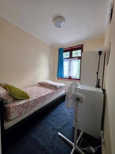 een kleine kamer met 2 bedden en een ventilator bij SAI Residence in Ilford