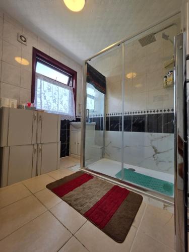 een badkamer met een douche met een glazen wand bij SAI Residence in Ilford