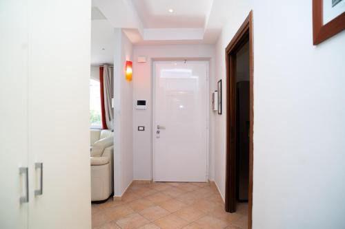 a hallway with a white door and a couch at Moderna villa con piscina a due Passi dal Golf Club in Pavona
